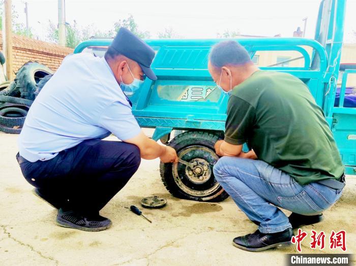 賽旦與民警共同維修三輪摩托車?！∫懒窘?攝