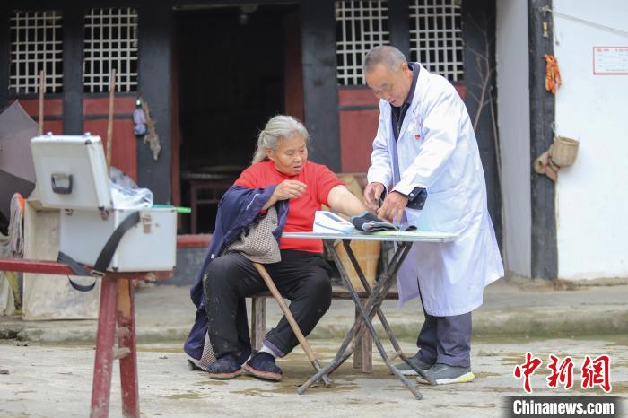 資料圖，貴州村醫(yī)給村民看病?！■暮陚?攝