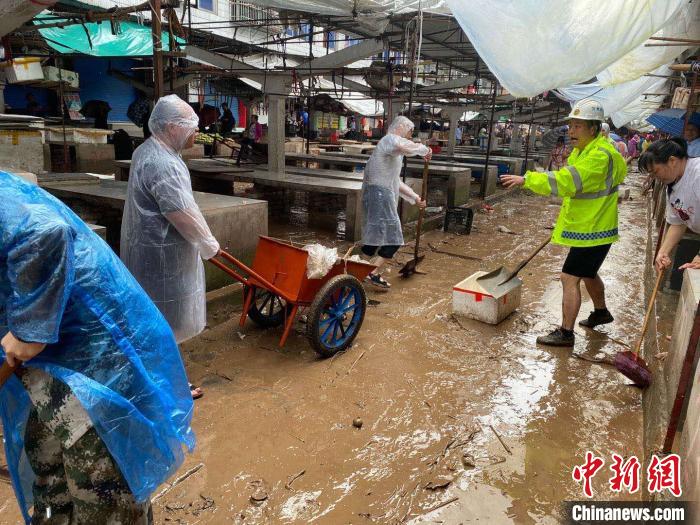 圖為7月26日，暴雨引發(fā)的洪水過境后，重慶萬州區(qū)分水鎮(zhèn)政府干部職工及志愿者清掃淤泥和垃圾?！　≈貞c萬州區(qū)委宣傳部供圖 攝