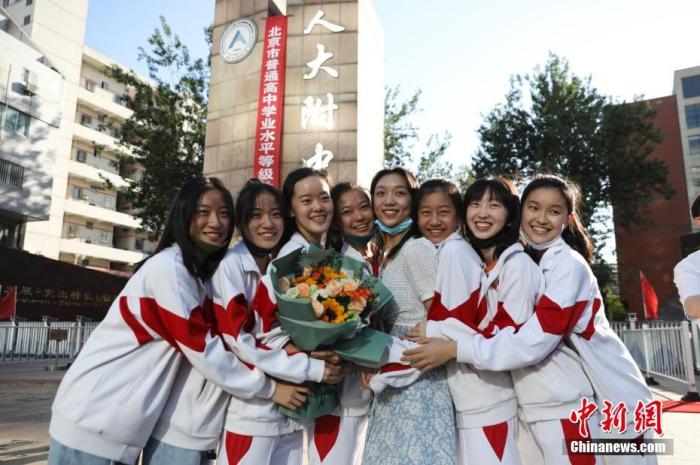 資料圖：6月10日，在北京人大附中高考考點(diǎn)外，考生們相擁拍照留念。當(dāng)日，北京市2021年高考結(jié)束?！?<a target='_blank'  data-cke-saved- ><p  align=