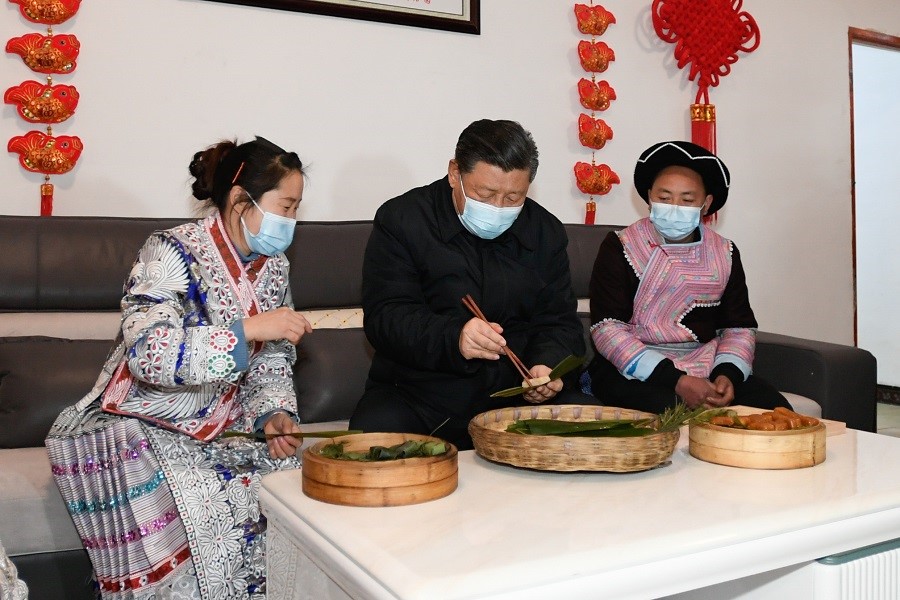 2021年2月3日下午，習(xí)近平在貴州畢節(jié)市黔西縣新仁苗族鄉(xiāng)化屋村苗族村民趙玉學(xué)家，同一家人邊聊家常邊制作當(dāng)?shù)貍鹘y(tǒng)節(jié)日食品黃粑。新華社記者 李學(xué)仁 攝